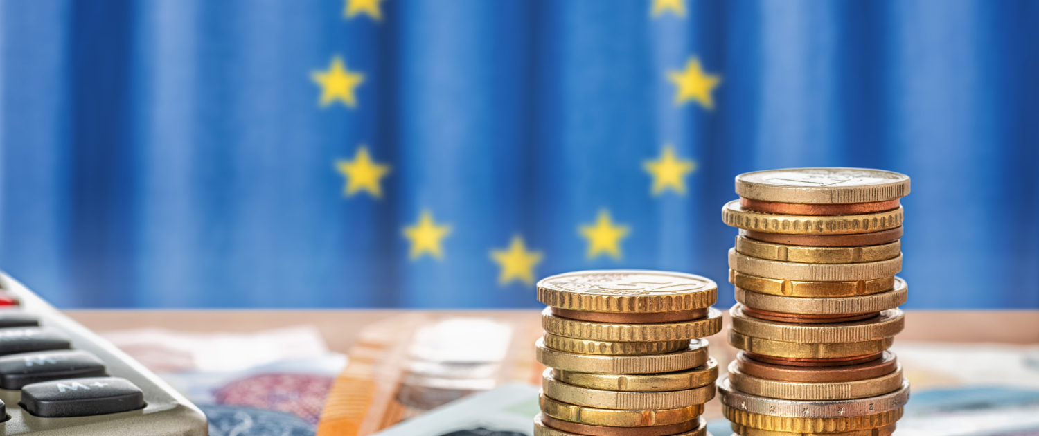 Geldscheine und Münzen vor der Flagge der Europäischen Union