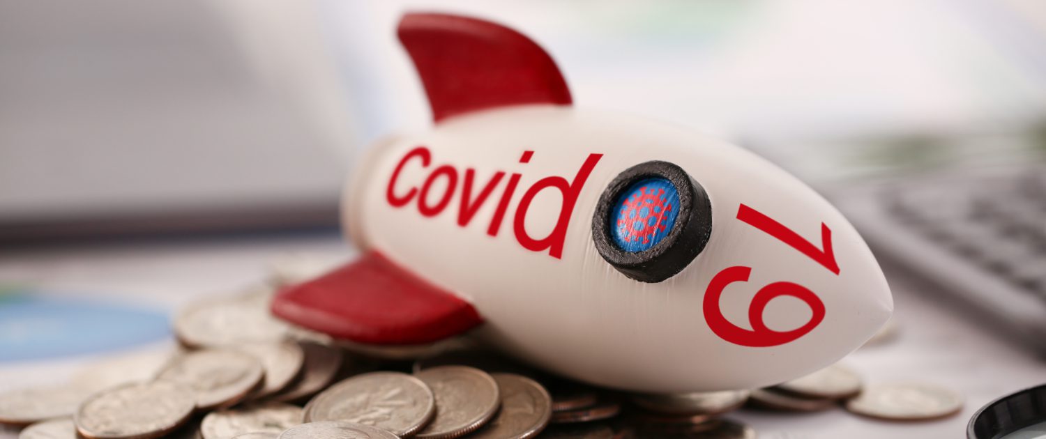 Rocket with inscription Covid 19 fell on a pile of coins