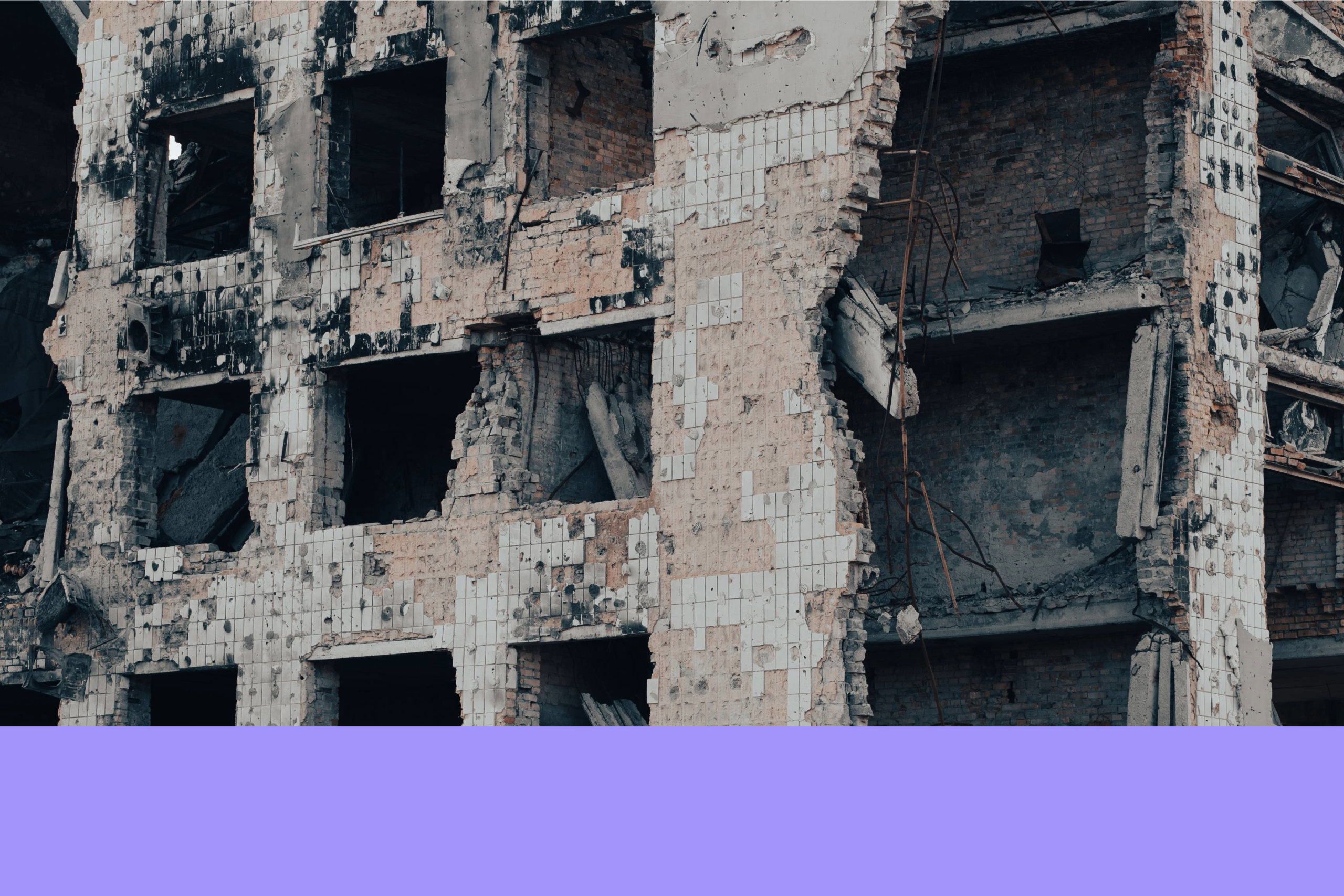A heavily damaged and partially collapsed building with exposed bricks and broken walls.